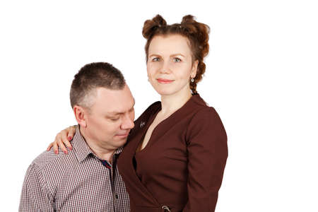 portrait of a married couple in the studio on white background. man looking at his wife's chest