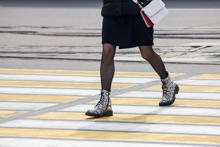 pedestrians cross the street at a pedestrian crossing on spring dayの写真素材