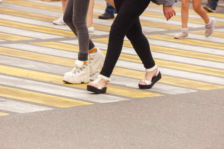 pedestrians walking on a crosswalk on sunny summer dayの写真素材