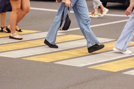pedestrians walking on a crosswalk on sunny summer dayの写真素材
