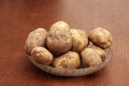plate with raw potatoes on the table. indoor daylightの写真素材