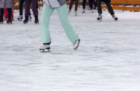 legs of people skating in winter day closeup