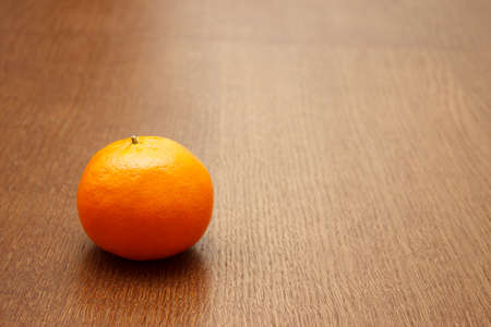 bright orange tangerine on the table lying on wooden table. indoor closeupの写真素材
