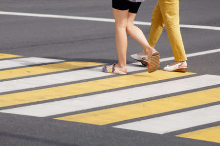 people crossing the road at a pedestrian crossing. leg closeup. outdoor on sunny summer dayの写真素材