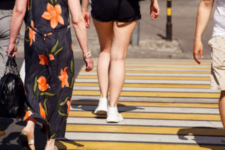 people crossing the road at a pedestrian crossing. leg closeup. outdoor on sunny summer dayの写真素材