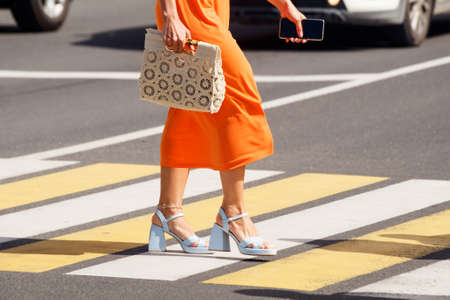 people crossing the road at a pedestrian crossing. leg closeup. outdoor on sunny summer dayの写真素材
