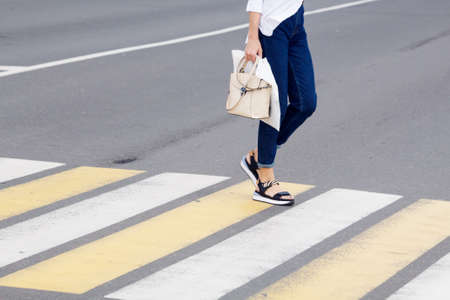 people crossing the road at a pedestrian crossing. leg closeup. outdoor on sunny summer dayの写真素材