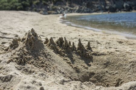 Abstract sandy castle on the beach. Close up view. Close up view. Selective focus. Copy, negative space. Natural texture backgroundの写真素材