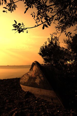 old boat in the beach at sunsetの写真素材