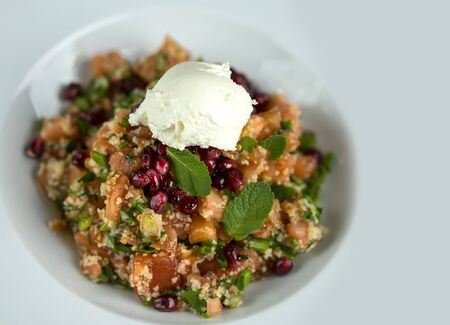 Salad of fresh vegetables, pomegranate seeds and ice cream, top view