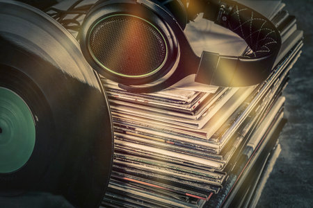 Close up of vinyl records with headphones on dark background. music concept.