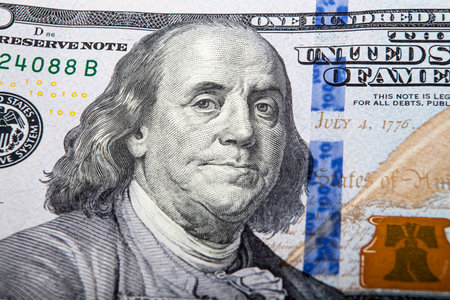 Close up of one hundred dollar banknote with Benjamin Franklin as background