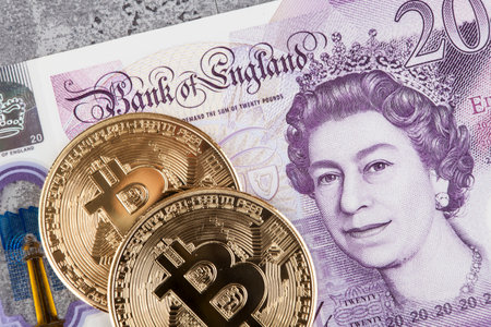 Bitcoin coins on the background of British pound banknotes.の写真素材