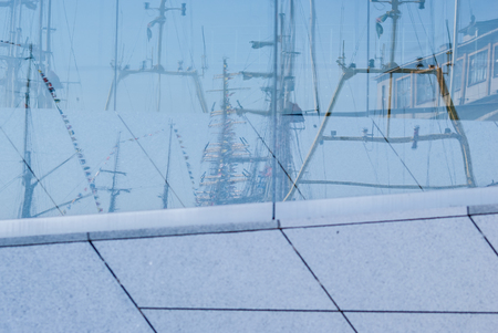 Reflections of masts of ships on a sunny day