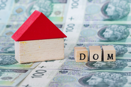 Wooden model of a house standing on polish money, "dom" means "house"の写真素材