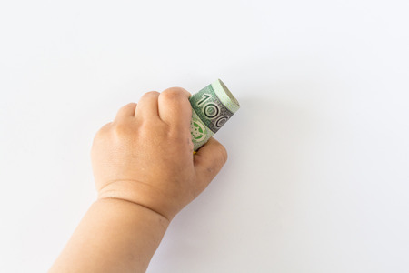Baby hands playing with polish moneyの写真素材
