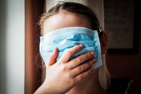 Pretty little European girl with a medical face mask onの写真素材