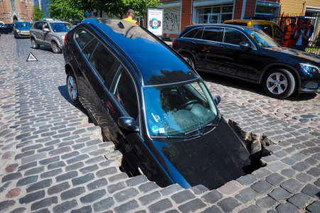 Riga/Latvia - June 5, 2020: Car fell into sinkhole which had opened after street surfacing caved in on Gertrudes Street during hydraulic testsのeditorial素材