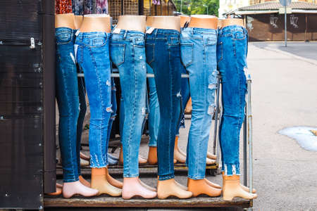 Legs of women mannequins dressed in various jeans in a market outdoorsの写真素材