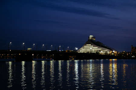 Latvian National library and Stone bridge over Daugava river in Riga. Night illuminated scene. Defocusedの写真素材