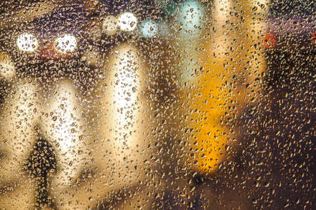 Rainy day, rain drops on window, rain and traffic lights bokeh, traffic jam. Defocusedの写真素材