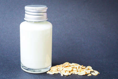 Small glass bottle with oat milk and oatsの写真素材