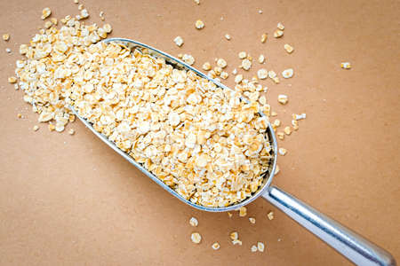 Raw oat flakes in a metal scoop, zero wasteの写真素材
