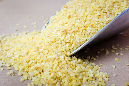 Raw bulgur on a food scoop in a zero waste shopの写真素材