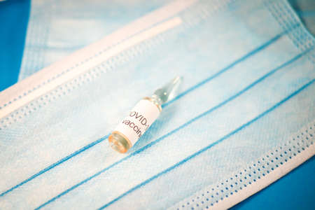 Glass ampoule with vaccine COVID-19, Vaccination against coronavirus helps strengthen immunity. Selective focusの写真素材