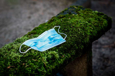 Victim of Coronavirus Covid 19, conceptual photo with protective medical mask on a stone tomb in the cemetery. Death from Covid 19の写真素材