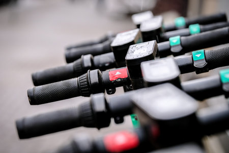 Lined up public electric scooters for rent in the city. Electric scooter transportation. Electric scooters steering wheels.の写真素材