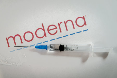 Riga, Latvia: January 12, 2021: Moderna Covid-19 vaccine concept. Close-up of a syringe and and, the Moderna company logo in the background. Defocusedのeditorial素材