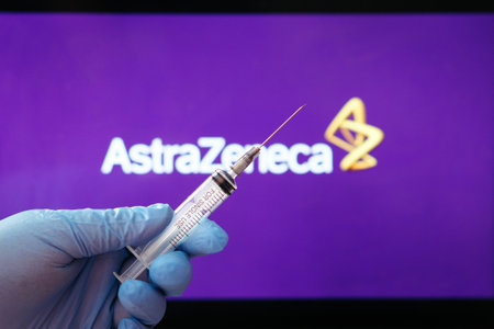 Riga, Latvia: January 28, 2021: AstraZeneca Covid-19 vaccine concept. Close-up of a syringe and and, the AstraZeneca company logo in the background. Defocusedのeditorial素材