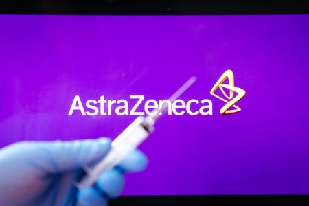 Riga, Latvia: January 28, 2021: AstraZeneca Covid-19 vaccine concept. Close-up of a syringe and and, the AstraZeneca company logo in the background. Defocusedのeditorial素材