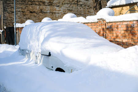 Car under a thick layer of snow after heavy snowfallの写真素材