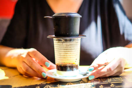 Woman holds cup of Vietnamese coffee. Defocusedの写真素材