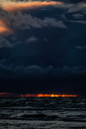 Fantastic view of the dark overcast sky. Dramatic and picturesque evening sunset scene over the sea. Storm clouds, storm passing over sea, dramatic clouds after storm at sunset. Defocusedの写真素材