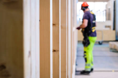 Contractor carpenter worker in construction zone. Worker and wooden constructions. Wooden skeleton framing building. Defocusedの写真素材