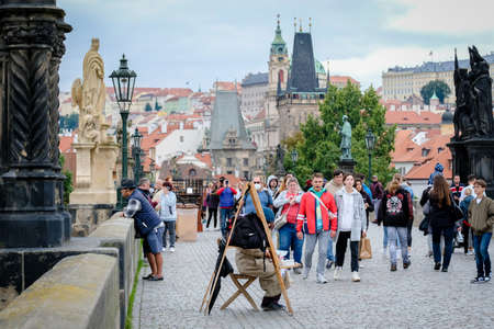 PRAGUE, CZECH REPUBLIC - September 19, 2021: Street vendors and tourist walking on the Charles Bridge, that crosses the Vltava river in Prague after pandemic  restrictions. Defocused.のeditorial素材