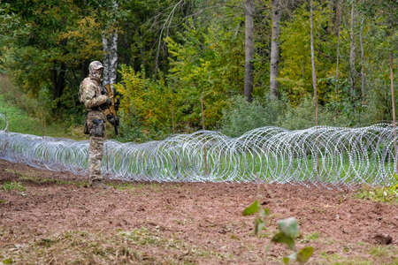 Indra, Latvia - September 28, 2021: Latvia - Belarus border, where Latvian State Border Guard and army begins to install a barbed wire fenceのeditorial素材