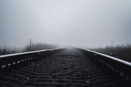 Railroad track in a thick white fog, forest in the background. Concept landscape. Sorrow, loneliness, impasse. Defocusedの写真素材