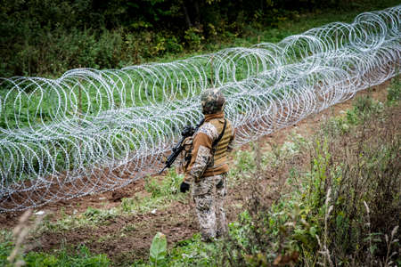 Indra, Latvia - September 28, 2021: Latvia - Belarus border, where Latvian State Border Guard and army begins to install a barbed wire fenceのeditorial素材