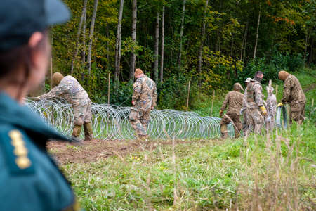 Indra, Latvia - September 28, 2021: Latvia - Belarus border, where Latvian State Border Guard and army begins to install a barbed wire fenceのeditorial素材