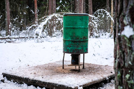 Manger for winter feeding of wild animals in forest. Forest animal feeder in winter. Defocusedの写真素材