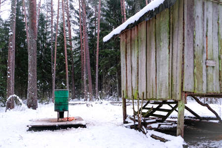 Manger for winter feeding of wild animals in forest. Forest animal feeder in winter. Defocusedの写真素材