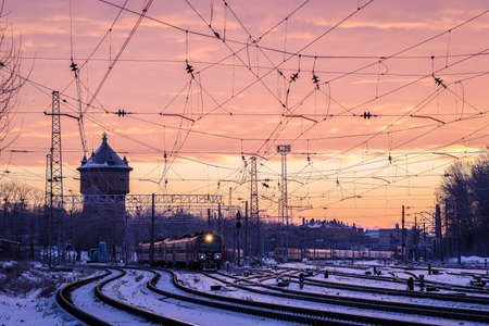 The passenger train travels on the tracks on a cold winter morning in the city. Selective focusの写真素材