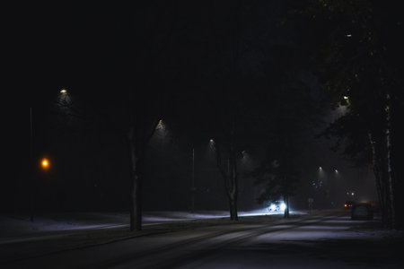 Cars in a snowstorm at night on the road in winter. Traffic in winter. Defocusedの写真素材
