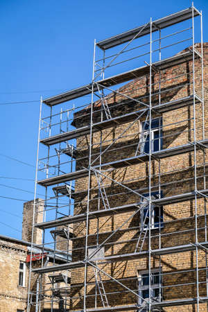 Reconstruction of an old brick house. Scaffolding for construction, construction site. Selective focusの写真素材