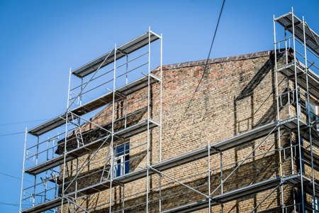 Reconstruction of an old brick house. Scaffolding for construction, construction site. Selective focusの写真素材