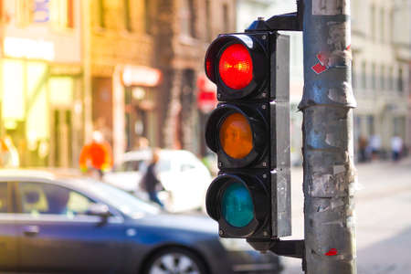 Pedestrian traffic light on the street junction in the city with beautiful bokeh, with cars and people in the backgroundの写真素材